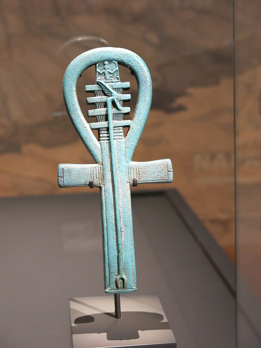 Amuleto egipcio presentado en el museo MET que representa tres jeroglíficos Ankh-Djed-Ouas.