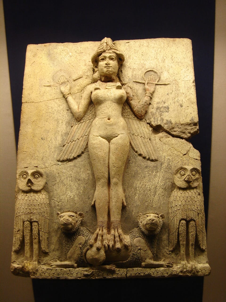 Relieve mesopotámico conocido como la "Reina de la Noche", representando a una figura femenina alada (posiblemente Inanna/Ishtar) con búhos y leones a sus pies. La figura está desnuda y lleva un tocado con cuernos, rodeada de símbolos de poder y divinidad.